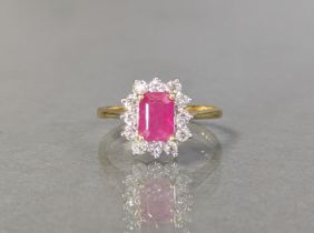 A ruby & diamond ring, the step-cut ruby weighing approx 1.2 carat, set within a border of round-cut