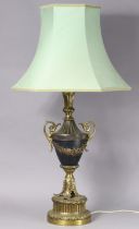 A 20th century gilt metal & ebonised table lamp of vase form on large cicular plinth base, with