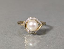 A 9ct gold ring set cultured pearl approx 7mm, within an ‘eye’ border set small diamonds, 2.7g, size