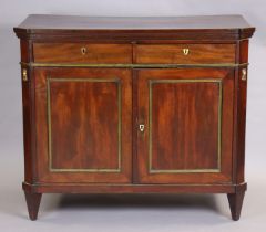 An early 19th century French mahogany buffet, the hinged top enclosing folding shelves, two frieze