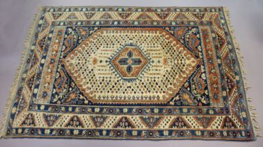 A Persian carpet of ivory ground with central medallion surrounded by floral motifs in multiple