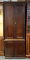 A late 19th/early 20th century oak hall cabinet enclosed by two pairs of fielded panel doors, on bun