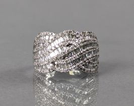 A DIAMOND RING, the broad panel of interwoven strands set numerous baguette & round-cut stones to