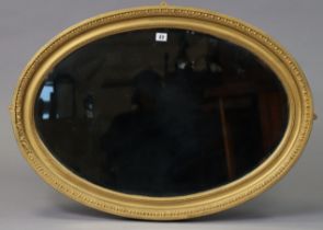 A late 19th/early 20th century gilt frame oval wall mirror with an egg-&-dart border & inset with