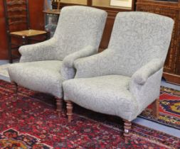 A pair of armchairs each with a rounded back, scroll-arms & sprung seat, upholstered in William
