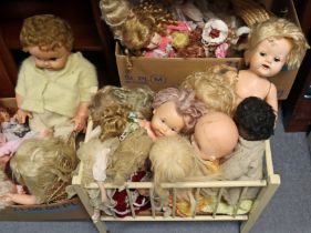 A collection of approximately forty various dolls; & a painted wooden dolls cot.