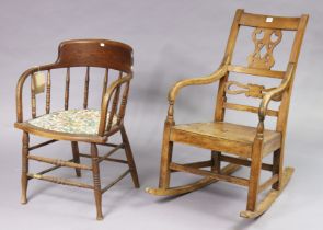 A Victorian beech splat-back rocking chair with a hard seat, & on square support with spindle