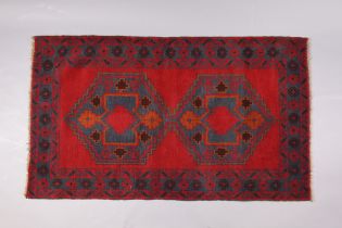 A Baluchi rug of crimson & deep blue ground, with repeating geometric design to centre within a