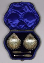 A pair of Edwardian silver butter dishes of fluted shell design, 10.5cm x 12.5cm; & a ditto pair