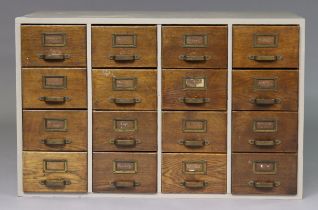 A mid-20th century oak counter-top office chest fitted four banks of four drawers with brass pull