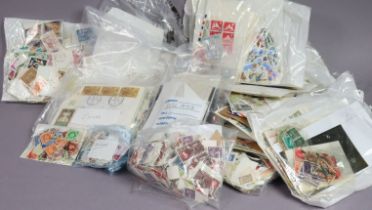 A collection of World stamps; loose, sorted into packets/envelopes.