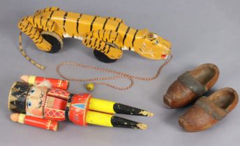 An early/mid-20th century painted wooden pull-along tiger toy, 39cm long; a similar soldier