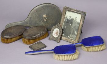 A pair of silver-backed clothes brushes; two silver photograph frames; a silver engine-turned