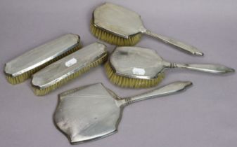 A George V engine-turned silver-backed five-piece dressing table set Birmingham 1934.