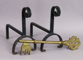 A pair of wrought-iron fire dogs, & a large brass ornamental key.