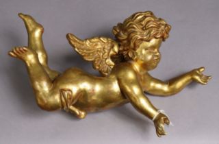 A carved giltwood flying cherub sculpture, 41cm long.