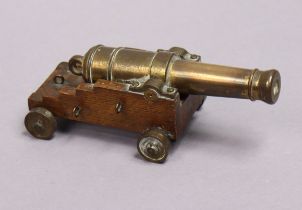 A brass signal cannon (both touch-hole & bore open), mounted on an oak base, 16.5cm long.