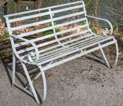 A light grey painted wrought-iron garden bench on shaped supports.