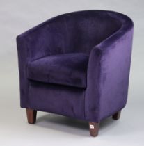 A modern tub-shaped chair upholstered purple material, & on short square tapered legs.