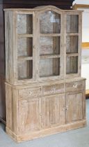 A pine dresser the upper part fitted two shelves enclosed by three glazed doors & with a rounded