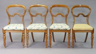 A set of four Victorian mahogany dining chairs each with an open kidney-shaped back, padded drop-