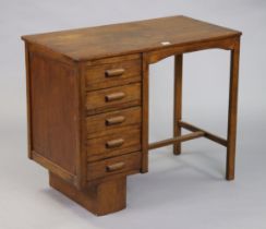 A vintage oak typist’s desk fitted five long drawers to the left-hand side, & on square supports,
