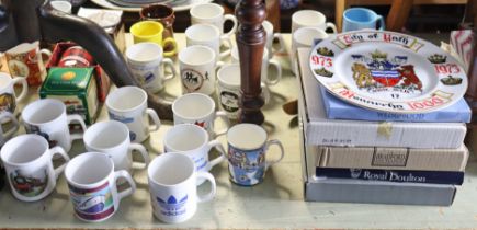 A collection of assorted collector’s plates & commemorative mugs.