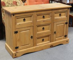 A “Corona” pine sideboard fitted with an arrangement of five drawers & a pair of cupboards, & on a