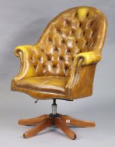 A Norwegian buttoned tan leather swivel office chair on five reeded splay legs.