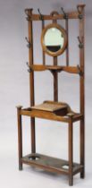 An Edwardian oak hallstand inset with a circular bevelled mirror to the top above a glove