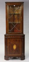 A reproduction inlaid-mahogany tall standing corner cabinet fitted two plate-glass shelves to the