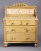 A Victorian pine chest inset five floral tiles to the stage-back, fitted three long graduated