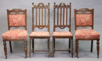 A pair of early 20th century carved oak rail-back dining chairs each with a padded seat, & on