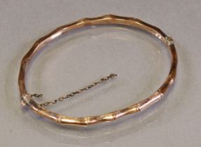 A late Victorian 9ct gold narrow stiff hinged bangle of bamboo design (4.5g).