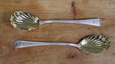 A pair of Victorian silver serving spoons, the Old English bead-edge stems with engraved floral