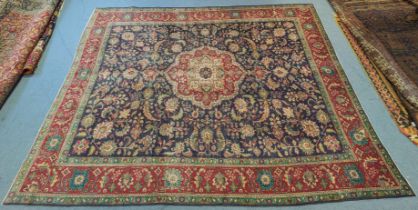 A Persian carpet of indigo ground featuring a central medallion surrounded by floral motifs within a