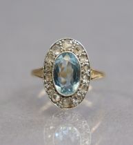 An early 20th century 18ct gold & platinum ring set oval-cut aquamarine within a border of rose