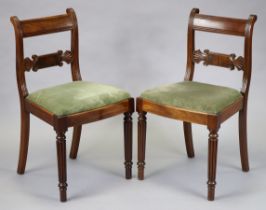 A pair of Victorian mahogany dining chairs with carved and shaped centre rails, reeded supports and
