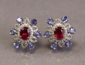 A pair of ruby, tanzanite & diamond earrings, the oval-cut rubies set within an open border of