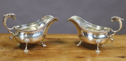 A pair of George V silver oval sauce boats with gadrooned rims, open leaf-scroll handles, each on