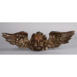 A Victorian carved limewood wall applique of a winged cherub, 42cm wide.