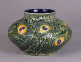 135. A modern Moorcroft pottery vase of squat round form, decorated with a peacock-feather design;