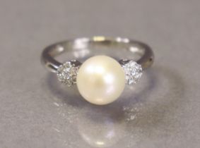 A pearl & diamond ring, the large cultured pearl approx. 8.5mm dia., with clusters of small diamonds