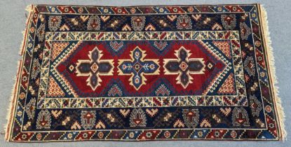 An Anatolian rug of madder ground with central row of star-shaped panels, and wide geometric