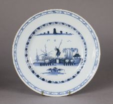 An 18th century English monochrome delft circular plate decorated with a chinoiserie river landscape