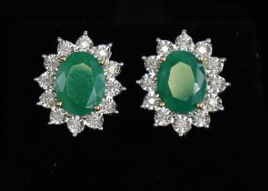 A pair of emerald & diamond ear studs, the oval-cut emeralds weighing approx. 3.8carats total, set