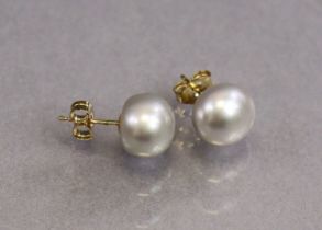 A pair of 9ct gold ear studs, each set large cultured button pearl, each approx. 9mm dia.