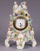 A Dresden porcelain mantel timepiece in rococo style case decorated with putti & encrusted flowers,