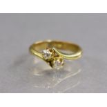 An 18ct. gold cross-over design ring set two small diamonds; size: I/J; 3.6gm.