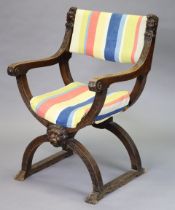 A 19th century walnut Savonarola chair with padded seat and back, scrolling arms and all-over carved